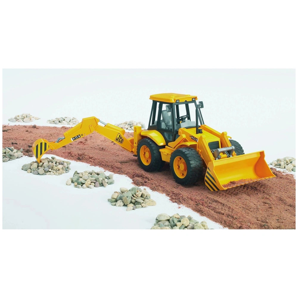 Yellow Bruder JCB 4CX Backhoe Loader toy on dirt path, surrounded by small rocks, features movable arm and front loader.