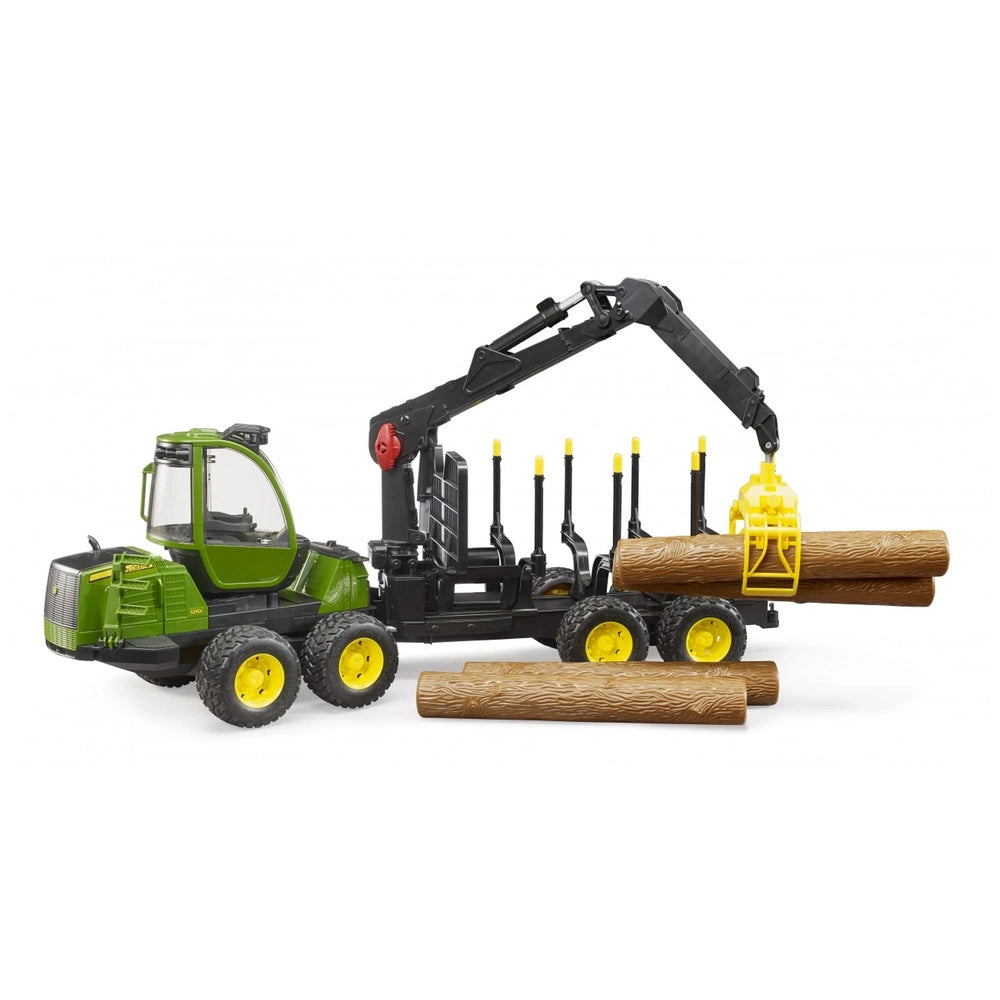 Green Bruder John Deere 1210E toy forwarder with crane lifting logs, yellow wheels, and detailed cabin design.