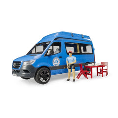 Blue toy camper van with a driver figure, red outdoor table, and chairs, designed for imaginative camping play.