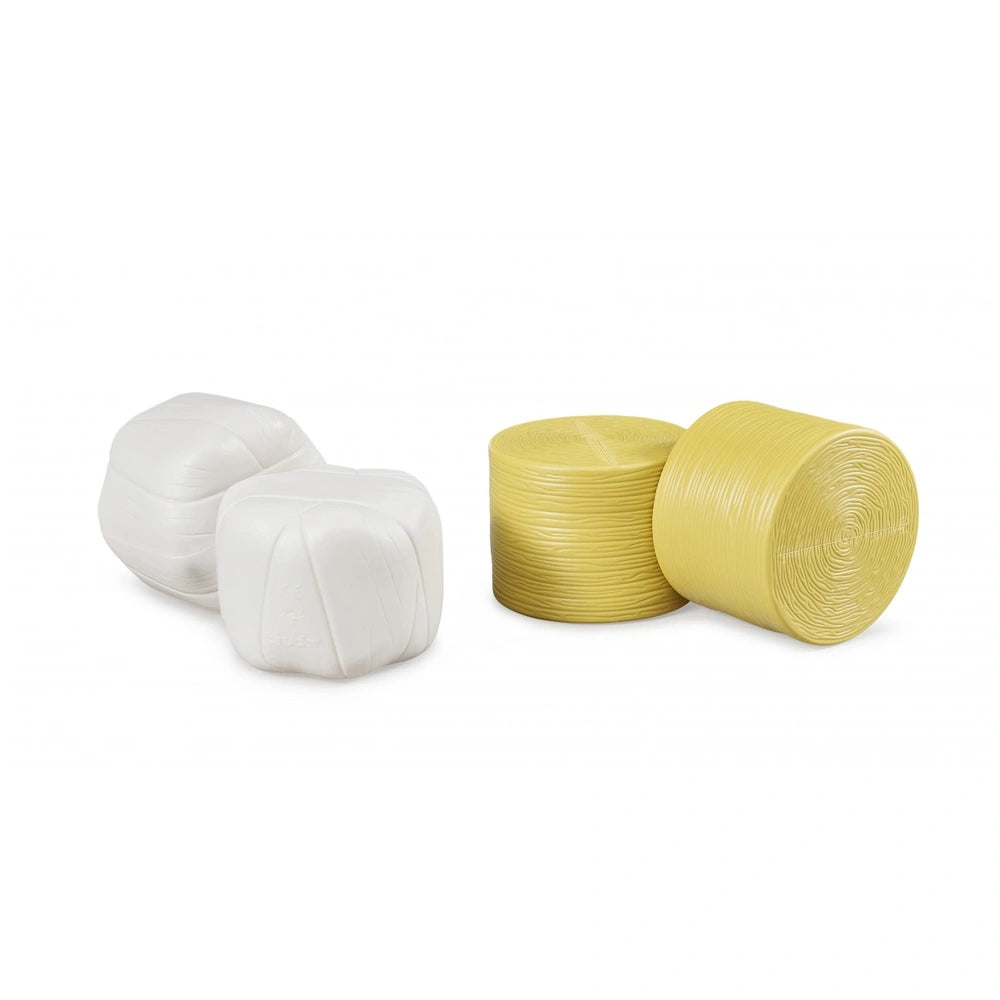 Four Bruder toy hay bales, with two white wrapped and two ochre-brown unwrapped, arranged in a set.