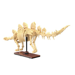 Cada Dinosaur Fossil Stegosaurus construction set features a brown wooden base and tan, white plastic dinosaur skeleton piece