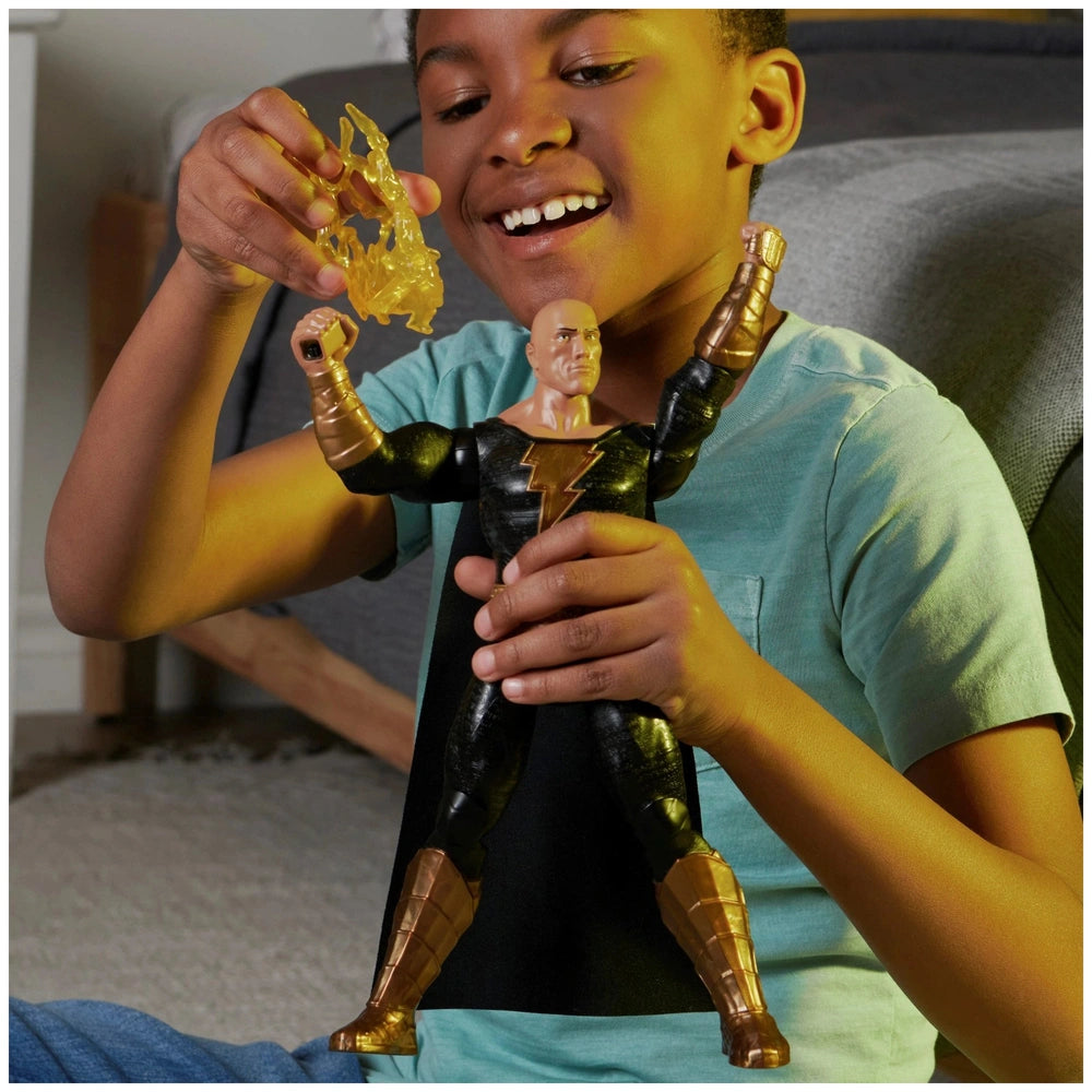 DC Comics Black Adam action figure held by a smiling boy in a cozy indoor setting, showcasing its muscular build and details.