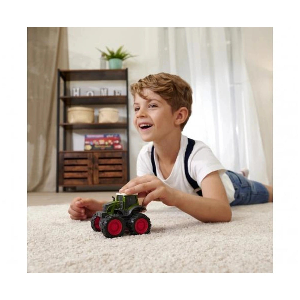 Dickie Fendt Friction Monster Tractor play vehicle with a blonde boy playing on a white carpet near a wooden bookshelf.