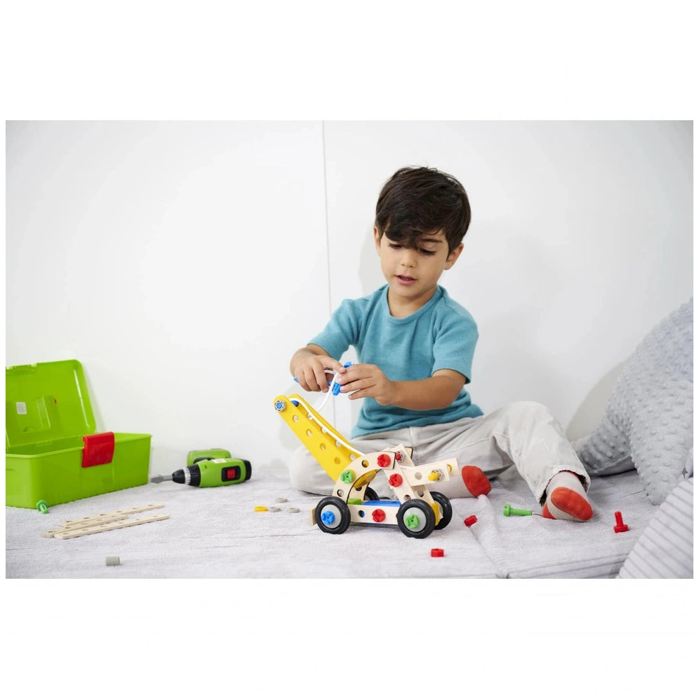 Eichhorn Constructor 4in1 construction set toys are being explored by a focused child seated on a white mat.