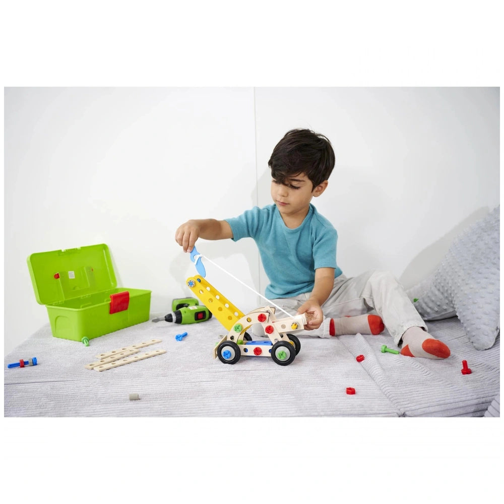 Eichhorn Constructor 4in1 construction set with a child playing on a carpeted floor, focused on a yellow toy with black wheel