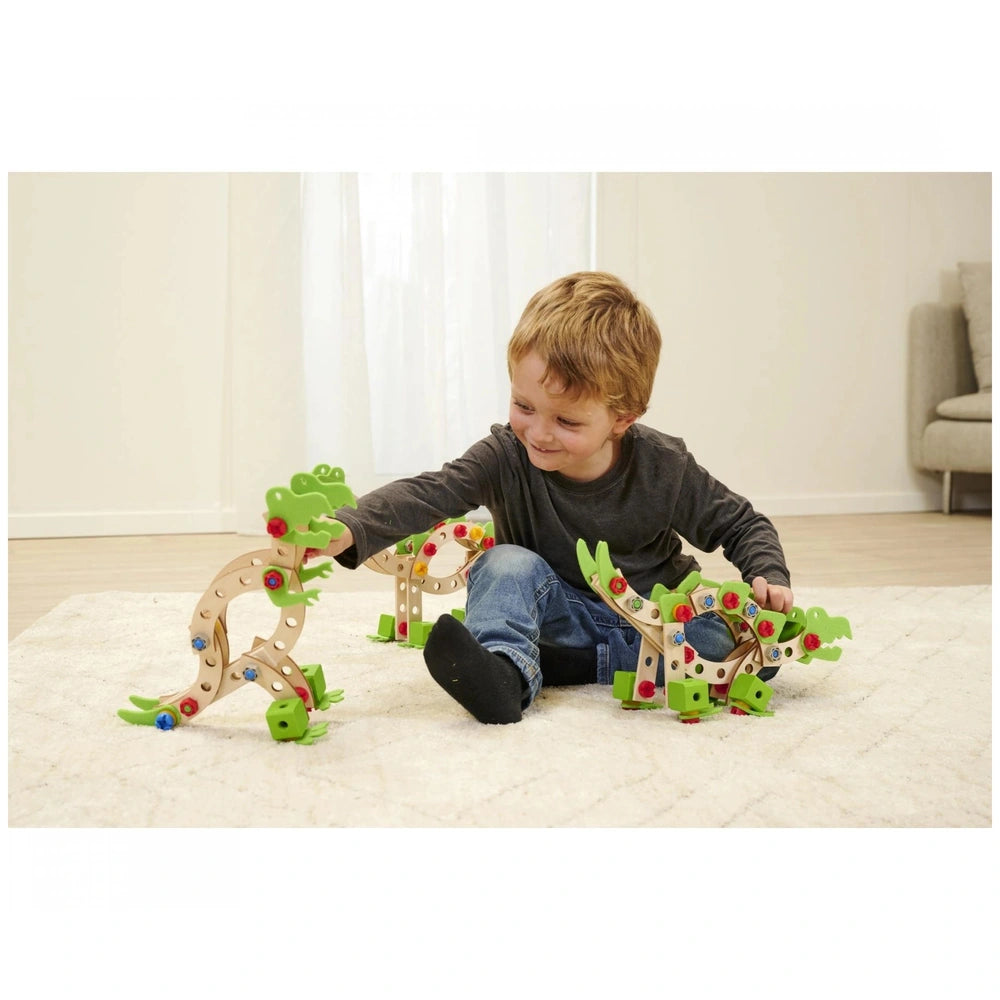 Eichhorn Constructor Dinosaur construction set is being played with by a smiling child on a white carpeted floor.
