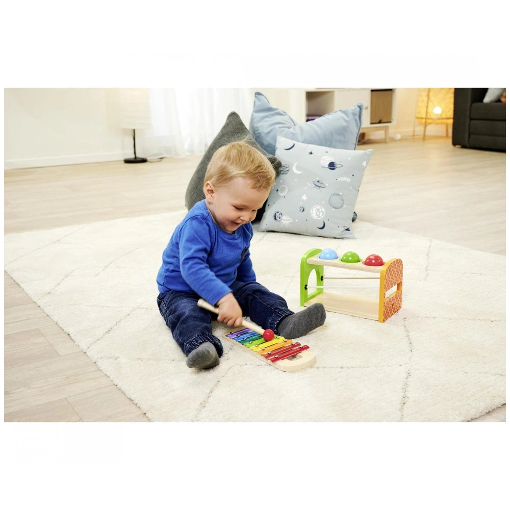 Eichhorn Hammer Bench with Xylophone: Child plays with colorful xylophone, focused in a modern living room setting.