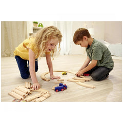 Eichhorn Train Track Playset with children assembling tracks and trains on a wooden floor in a cozy home environment.