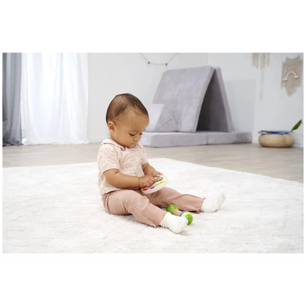 Eichhorn Wooden Music Set showing a young child playing on a carpet, engaged with colorful musical instruments.