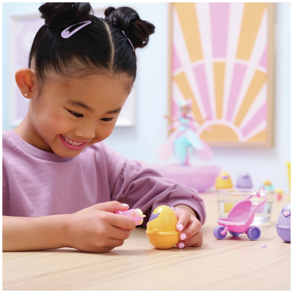 Hatchimals Alive Hatch N’ Stroll Playset with stroller toy and colorful mini figures is being enjoyed by a smiling girl at a 