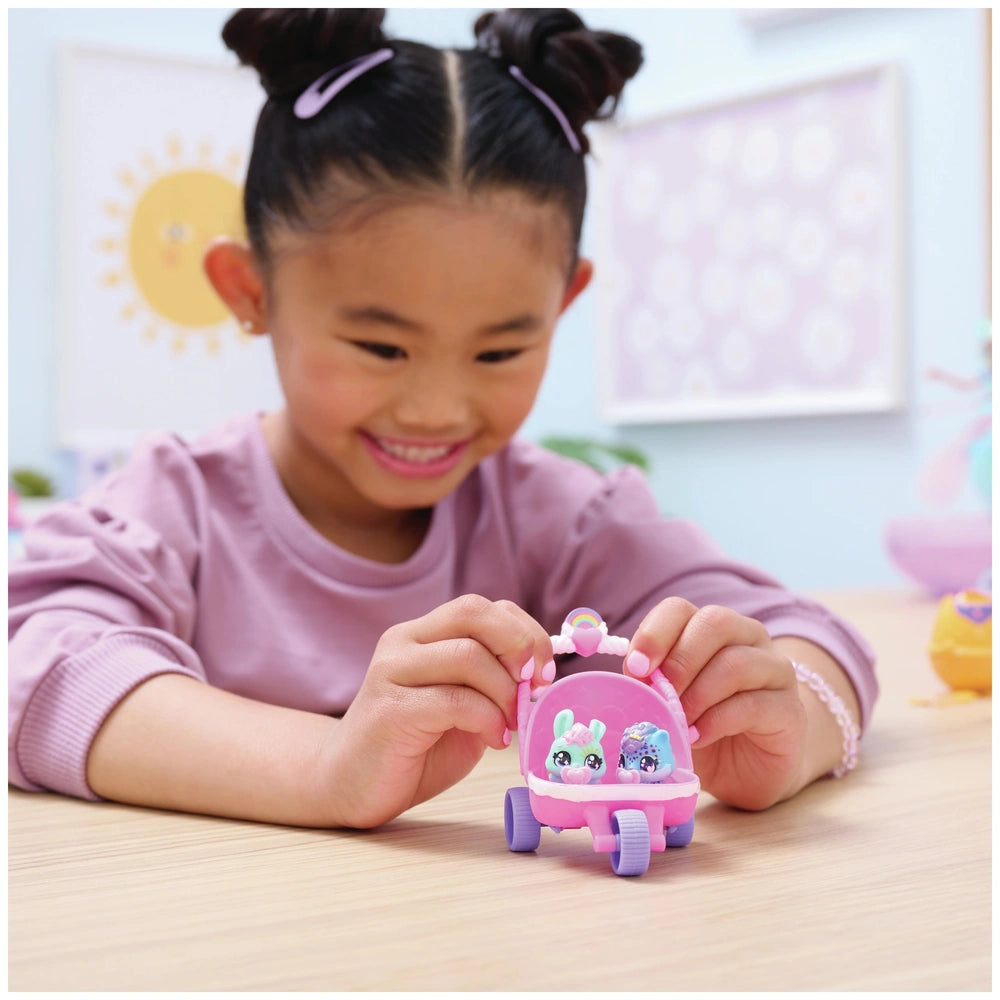 Hatchimals Alive Hatch N’ Stroll Playset is held by a smiling girl with dark hair styled in buns, wearing a purple top.
