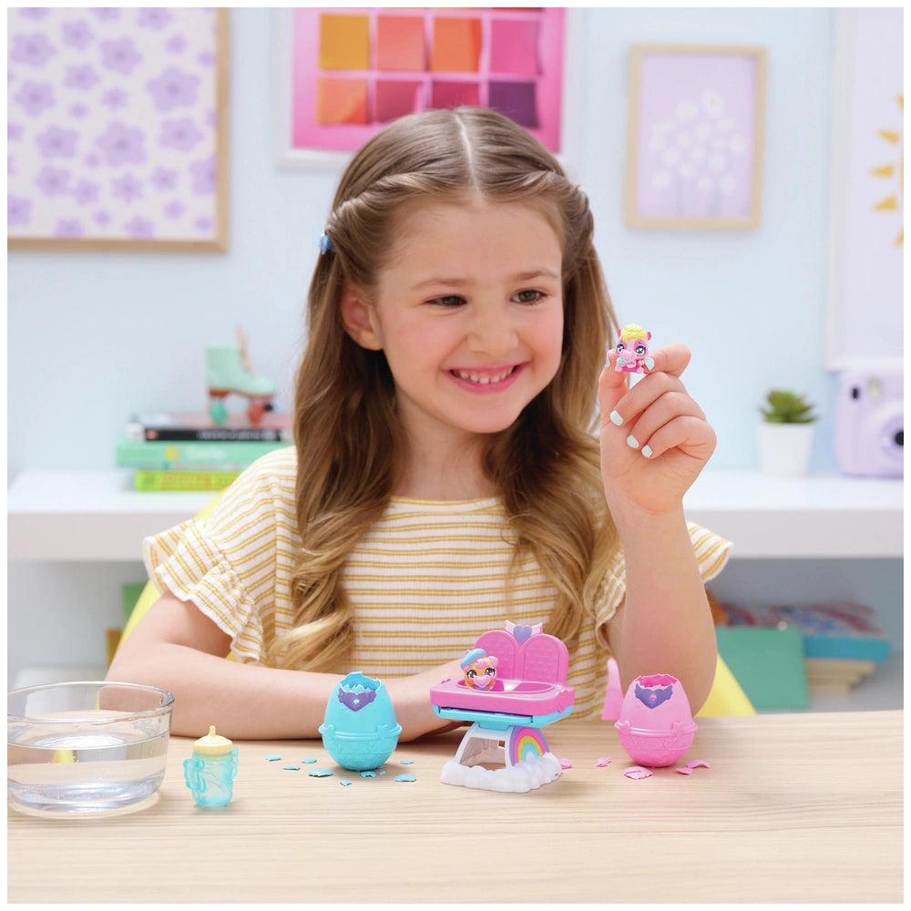 Hatchimals Alive playset displayed on a table, with a smiling girl holding a colorful toy in a vibrant playroom.