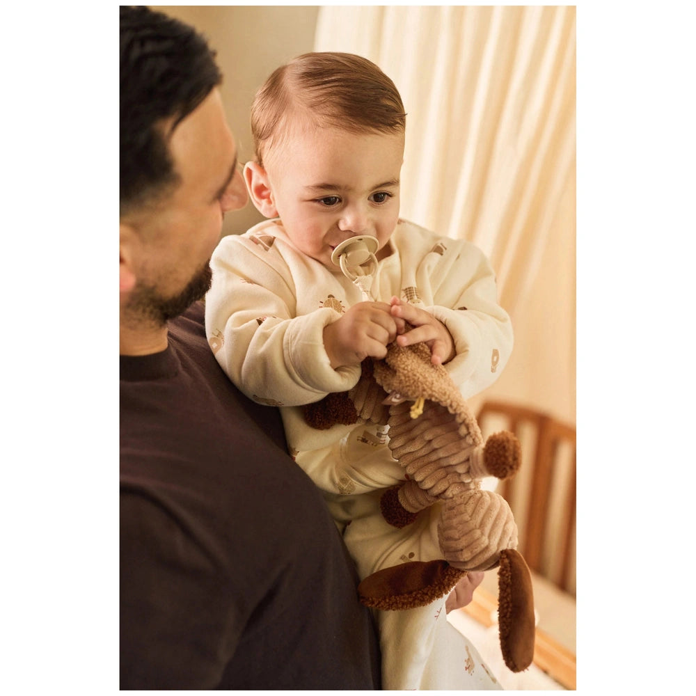 Jollein Pacifier Cloth Animal Friends with a smiling baby in a white onesie holding a soft brown stuffed animal, man in dark 