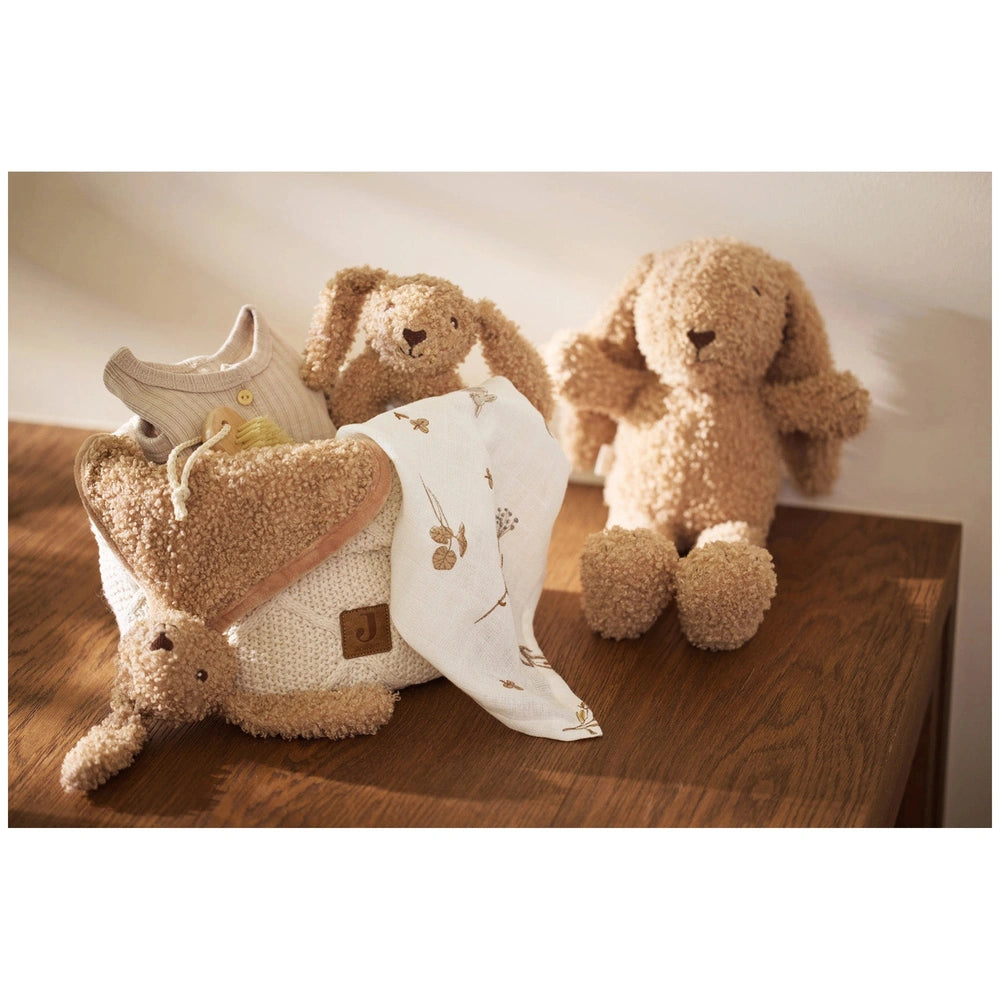 Jollein Pacifier Cloth Bunny Riverside displayed on a wooden table with two light brown teddy bears and a white bag with brow