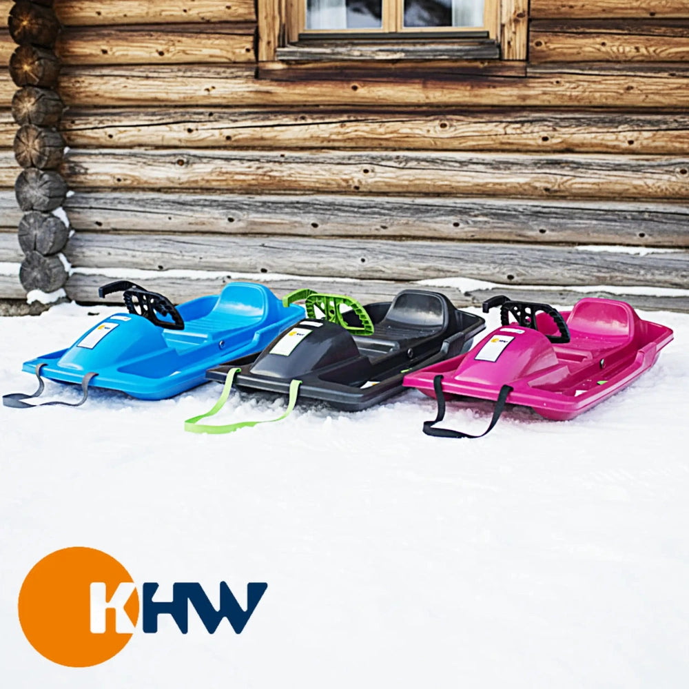 KHW Snow Fox Sled in anthracite color, surrounded by various plastic sleds on snow-covered ground.