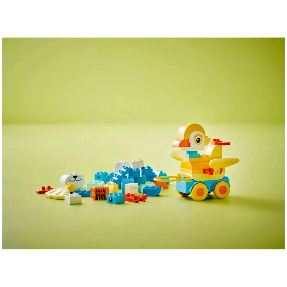 LEGO 3in1 Animals on Wheels construction set features a yellow toy train with orange wheels and blue front, surrounded by sca