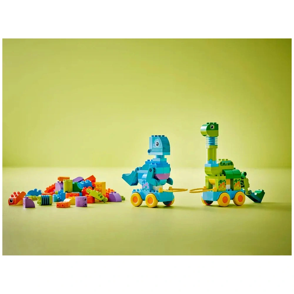LEGO dinosaurs-on-wheels set features colorful figures and a vehicle, arranged on a light green surface for imaginative play.