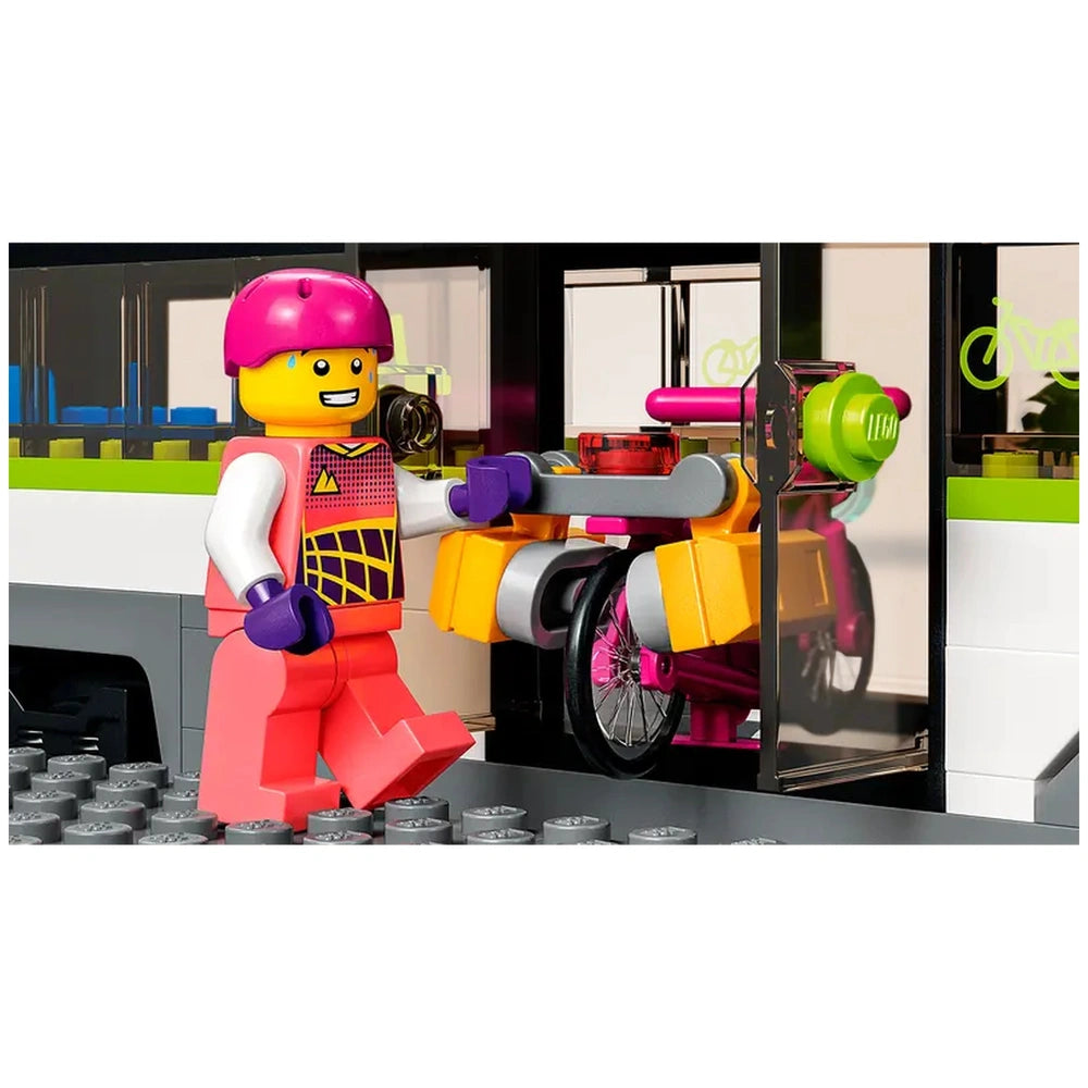 A cheerful LEGO figure in a pink helmet and vibrant outfit is pushing a colorful wheelchair towards a train car with large windows and a bright passenger area.
