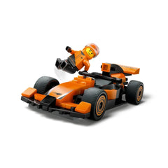 LEGO® City F1® Driver in orange race suit, jumping beside a sleek orange McLaren race car with detailed features and slick tires.