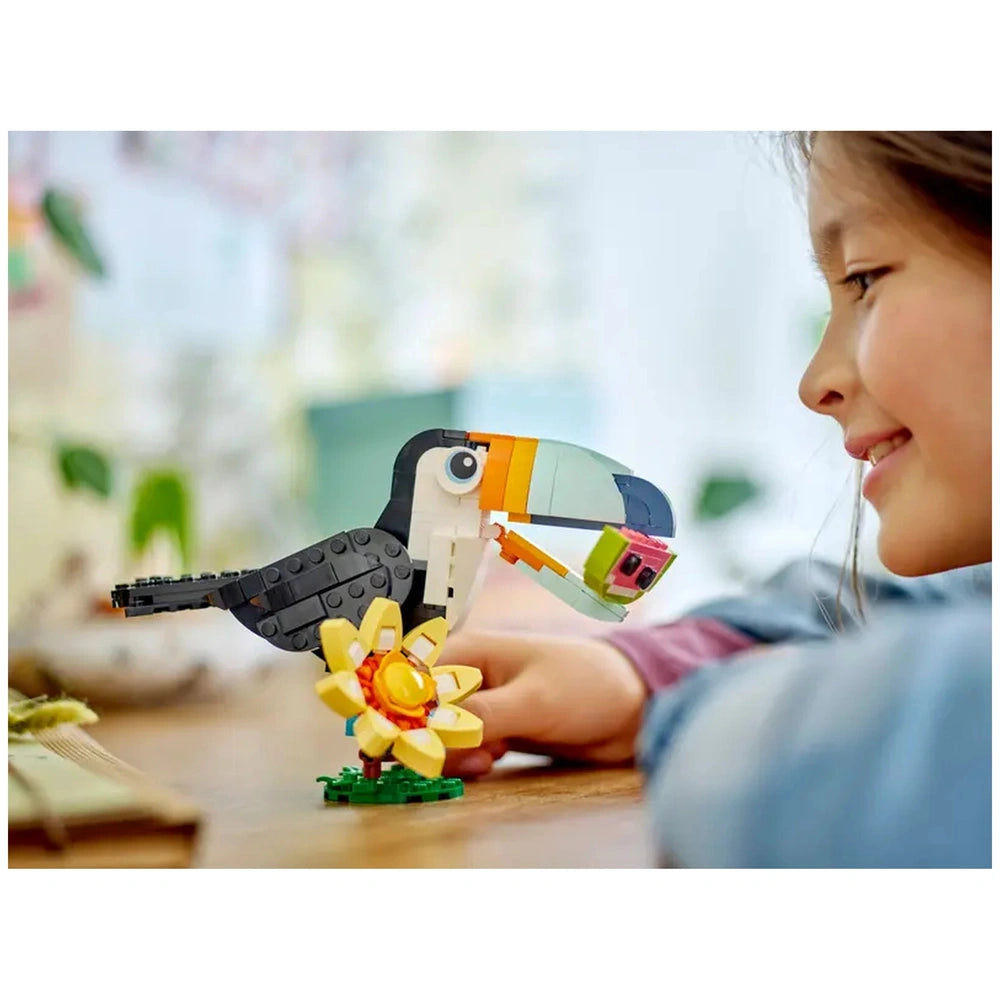 Colorful LEGO tropical toucan perched on a flower, as a child smiles and interacts with the vibrant building toy.