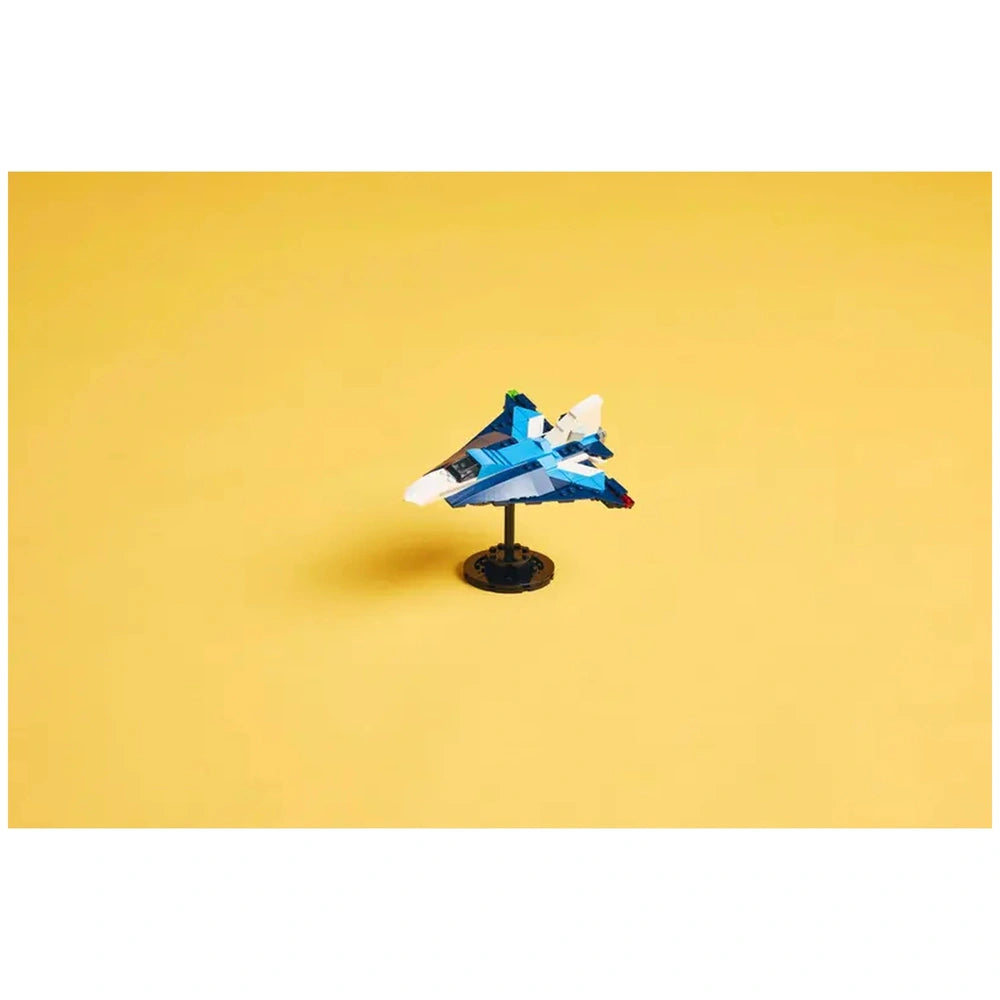 Blue and white LEGO® Creator Race Plane model on a black stand, set against a bright yellow background, showcasing its sleek design.