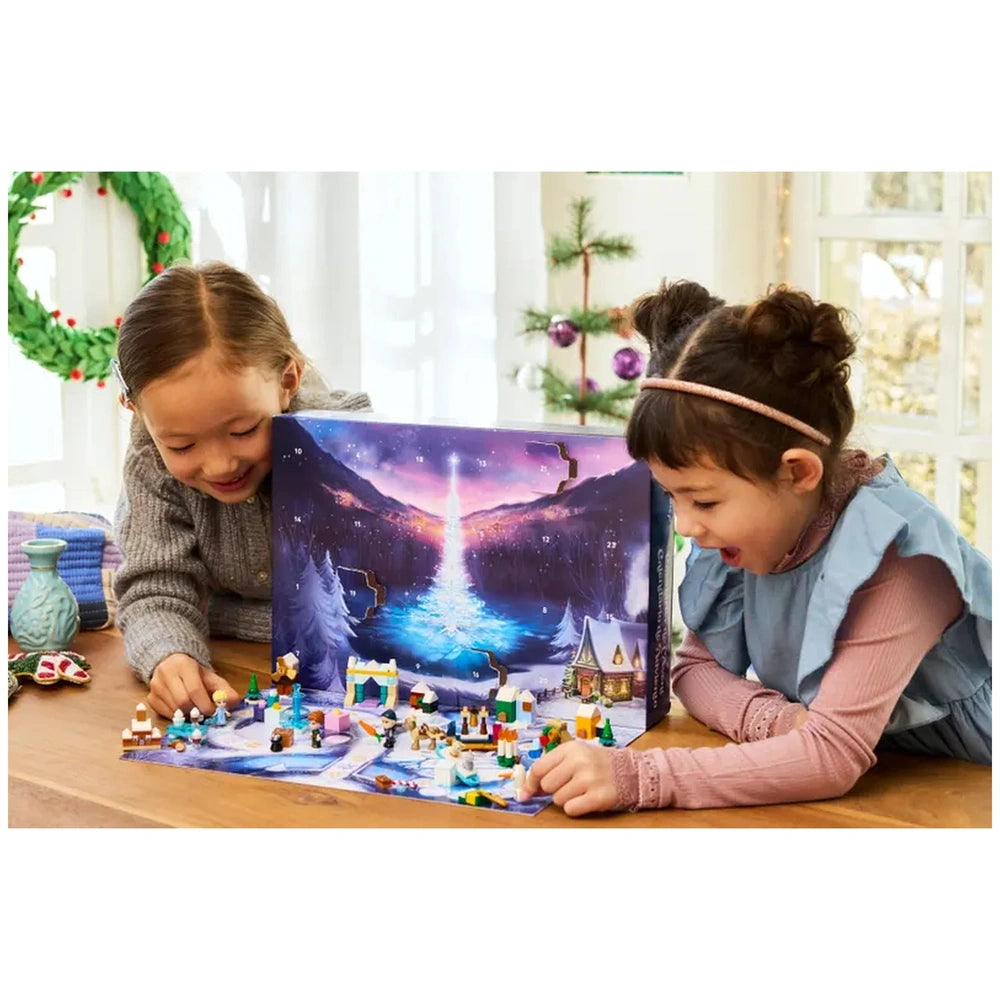 Two children joyfully interacting with the LEGO Disney Frozen Advent Calendar 2025, revealing mini builds against a festive winter landscape.