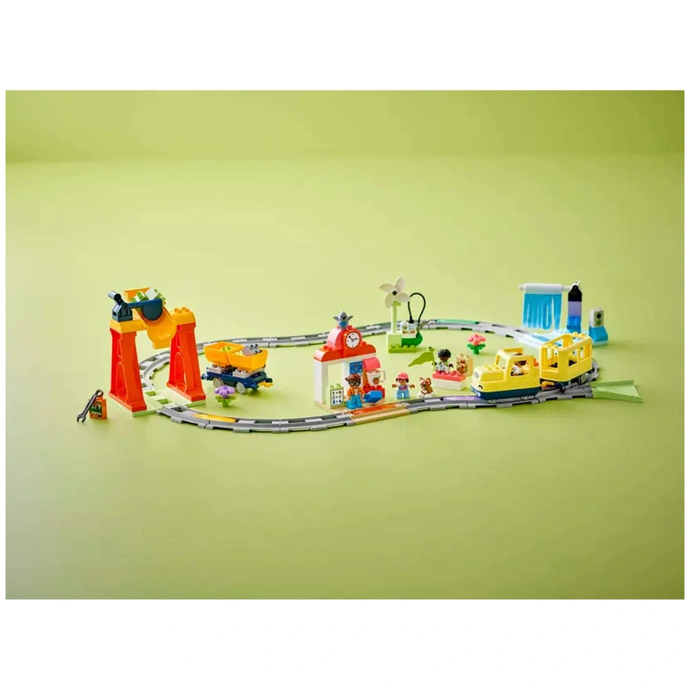 Colorful Lego Duplo Big Interactive Community Train set with a train station, figures, and accessories on a light green background.