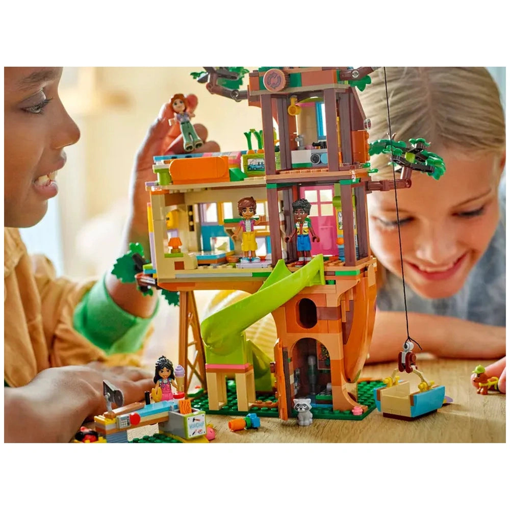 Friends play with the LEGO® Friends Friendship Tree House Hangout set, featuring colorful building elements and four minidolls.