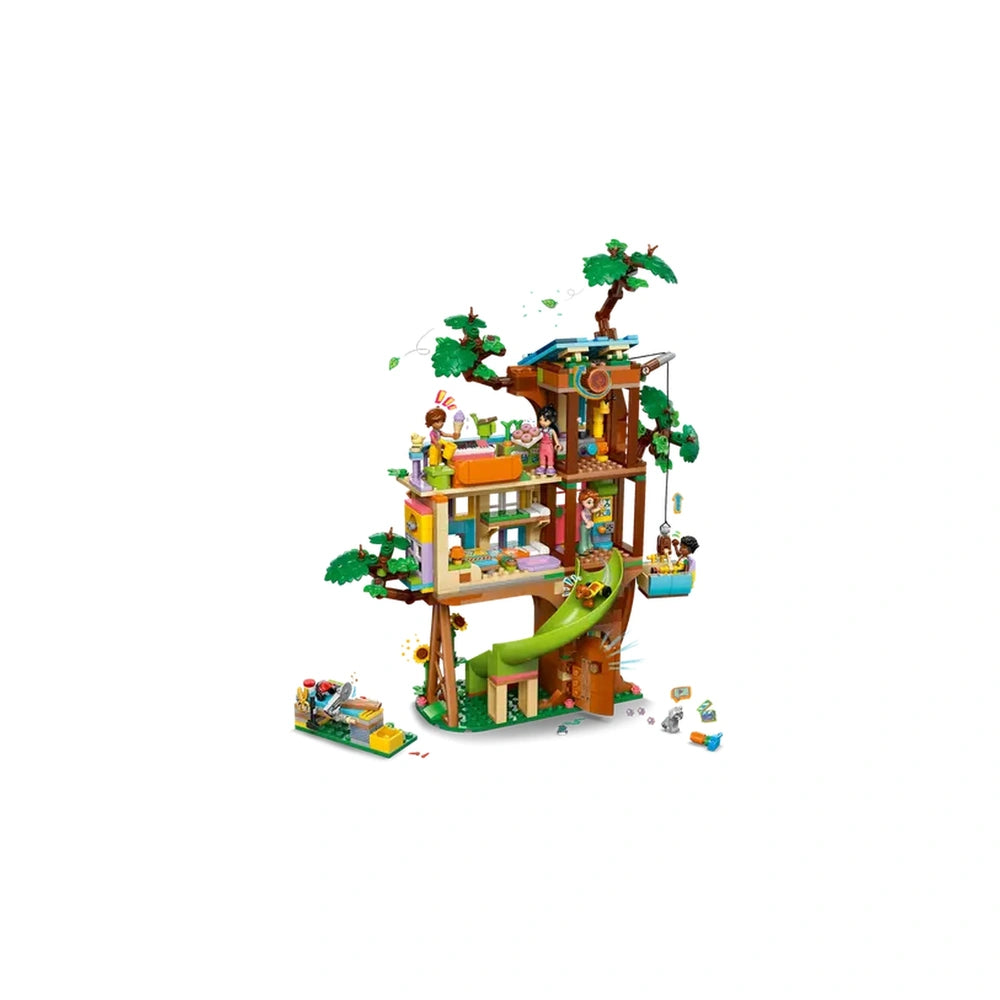 Colorful LEGO Friends Friendship Tree House, featuring four minidolls, a slide, and a dog figure, surrounded by green trees.