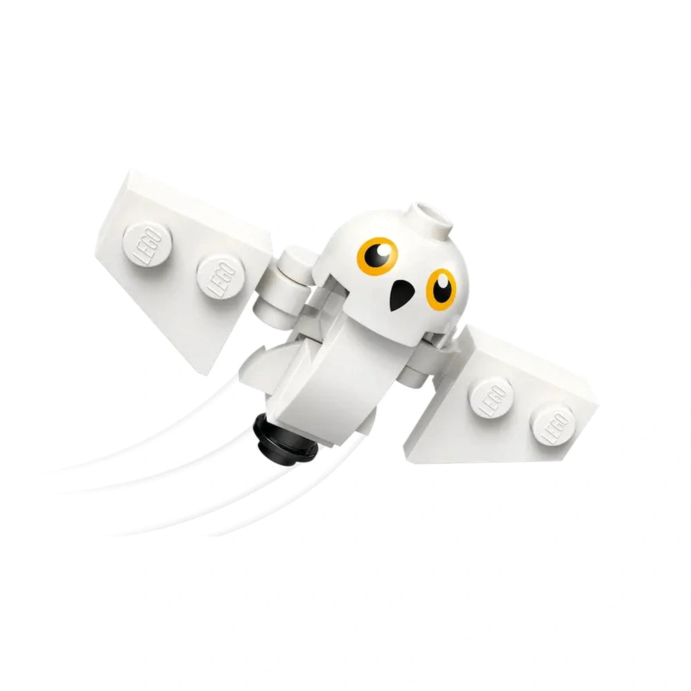 White LEGO owl figure with yellow eyes and outstretched wings, flying against a plain white background.