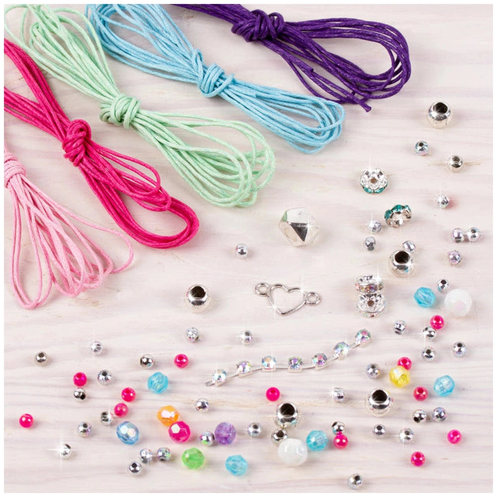 Rainbow Bling Bracelets featuring shiny multi-colored beads and smooth pink, green, and blue strings on a light wood table.