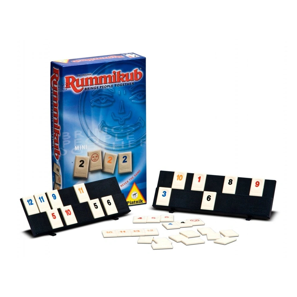 Rummikub Mini Mark 2 board game packaging features a blue background, a black game board, white game pieces, and instructions