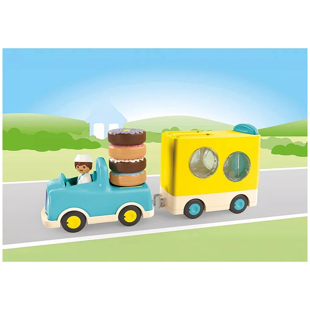 Playmobil Crazy-Donut-Truck in blue and yellow carrying three brown and white donuts, featuring clear plastic windows and bla