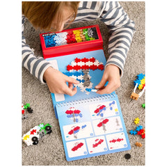 Plus Plus transportation activity pad features a child playing with red Lego pieces on a blue baseplate, surrounded by scatte