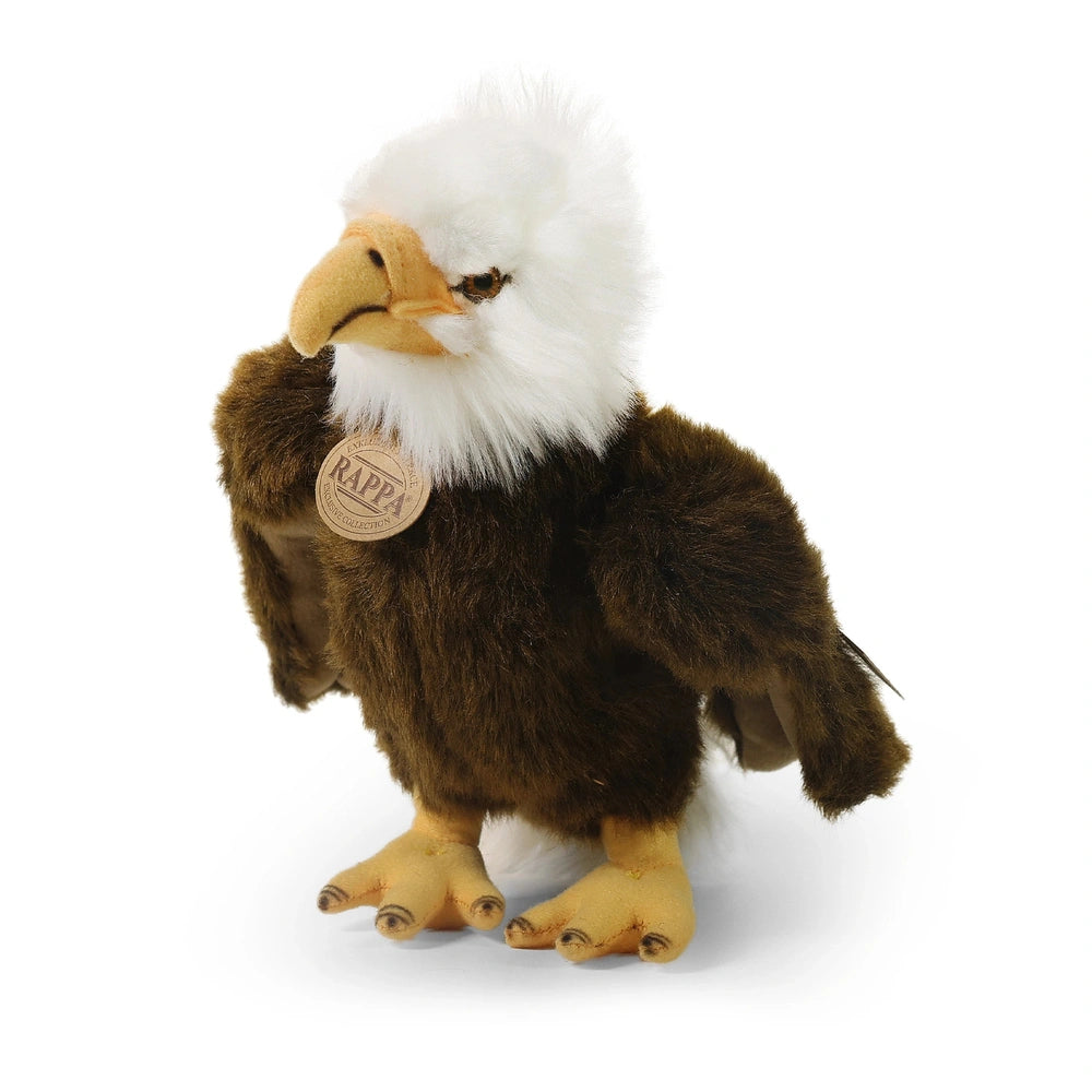 Plush eagle toy stands upright with realistic feather texture, featuring a brown body and white markings on a light backgroun