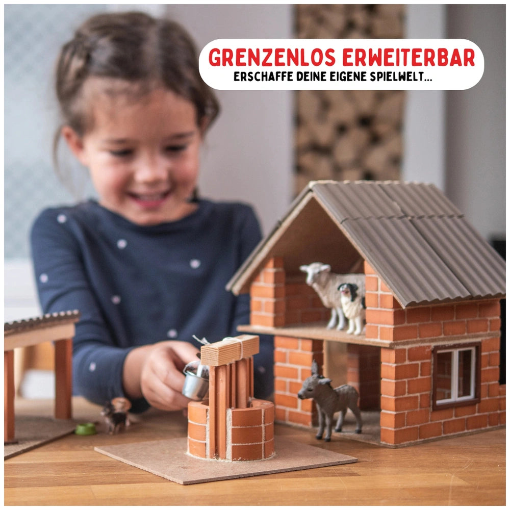 Teifoc arts and crafts set featuring a smiling girl with a model house, showcasing a sheep and dog figurines on the roof.